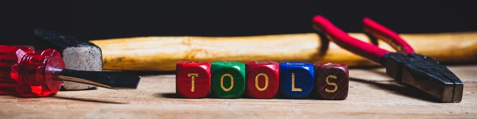 Different tools and the letters tools on a wooden surface Stock Photos