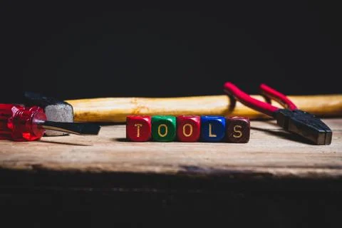 Different tools and the letters tools on a wooden surface Stock Photos