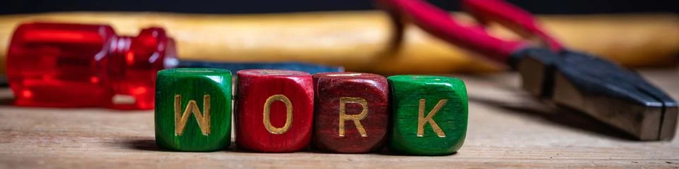 Different tools and the letters work on a wooden surface Stock Photos