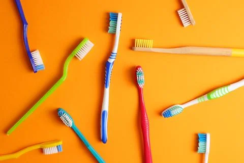 Different toothbrushes on a colored background. Dental care, oral health. Stock Photos