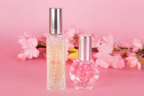 Different transparent perfume bottles with spring blooming tree branch on pin Stock Photos