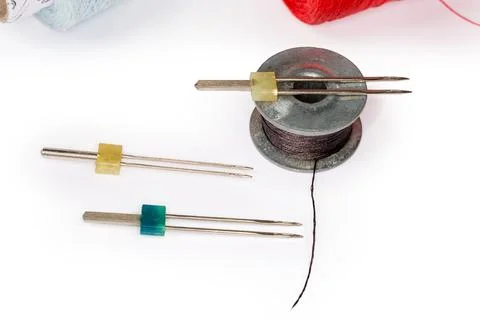 Different twin sewing machine needles and bobbin with black threads Stock Photos