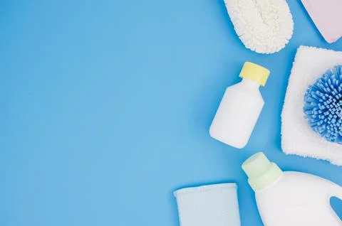 Different type sponges with detergent bottles blue backdrop Stock Photos