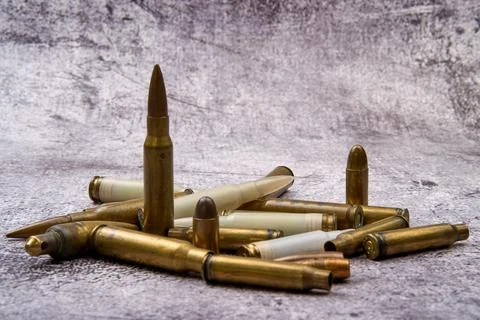 Different types of ammunition scattered on the ground. Stock Photos