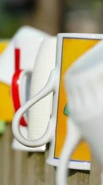 Different types and shapes of cups and mugs hanged upside down on the fence Stock Photos