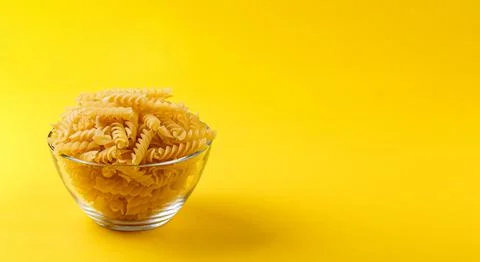 Different types and shapes of dry italian pasta on a yellow background Stock Photos