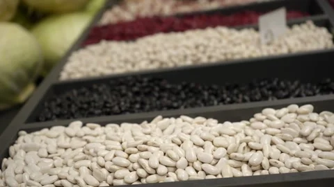 Different types of beans in black open containers on the store counter Stock Footage 232713762