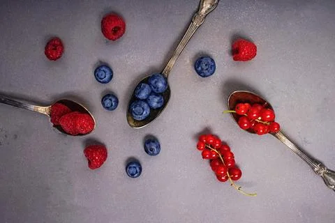 Different types of berries in the spoons. Foto stock