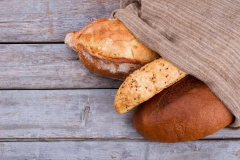 Different types of bread in burlap bag. Stock Photos