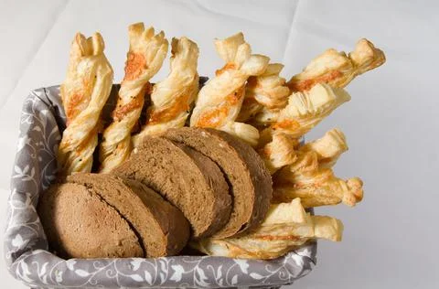 Different types of bread in a wicker basket. Stock Photos