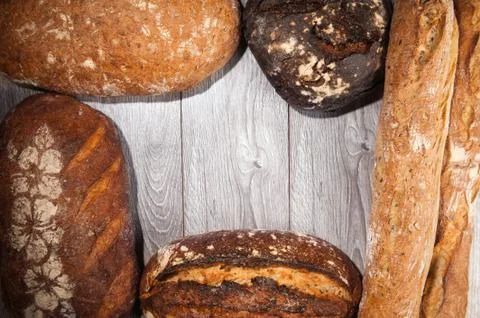 Different types of bread on wood background Stock Photos