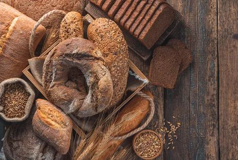 Different types of bread on a wooden background. Bakery products. Stock Photos