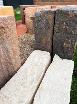 Different types of bricks stacked beautifully on green grass Stockfoto's