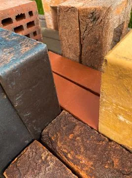 Different types of bricks stacked beautifully on green grass Stock Photos