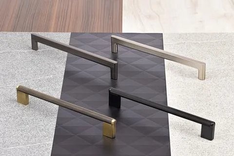 Different types of cabinet handles displayed on various surfaces in a spaci.. Stock-Fotos