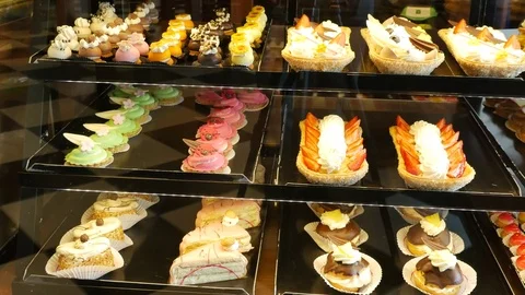 Different types of cakes in pastry shop glass display Stock Footage 79054462