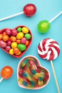 Different types of candies on blue background, copy space. Colorful birthday  Stock Photos