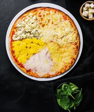 Different types of cheese on a big pizza Stock Photos