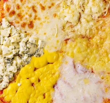 Different types of cheese on a big pizza Stock Photos