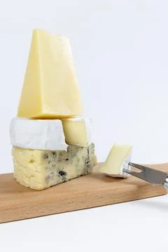 Different types of cheese, blue cheese and brie with a cheese knife on a ligh Stock Photos