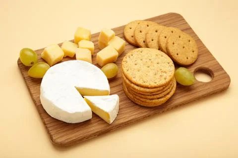 Different types of cheese with crackers and grape on wood serving cheese bo.. Stock Photos