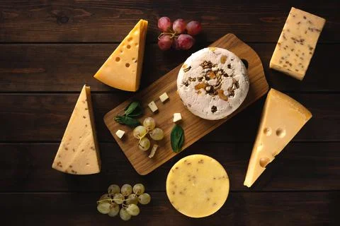 Different types of cheese on a cutting board top view Stock Photos