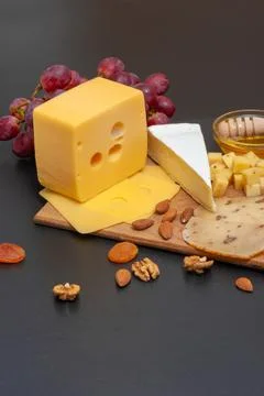 Different types of cheese on a graphite board Stock Photos