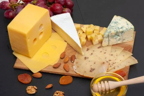 Different types of cheese on a graphite board top view Stock Photos