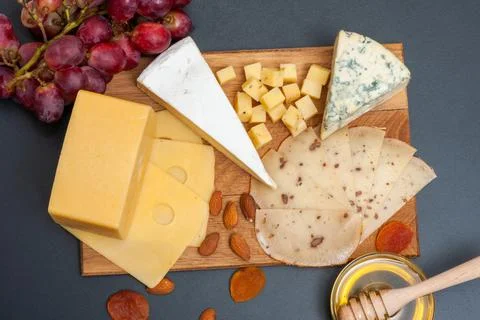 Different types of cheese on a graphite board top view Stock Photos
