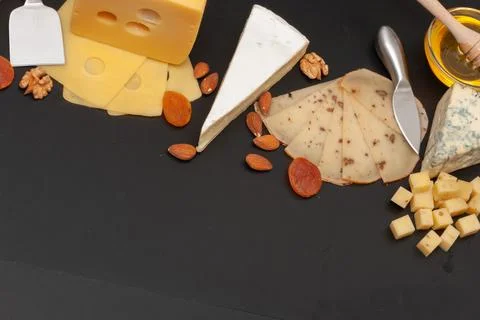 Different types of cheese on a graphite board top view Stock Photos