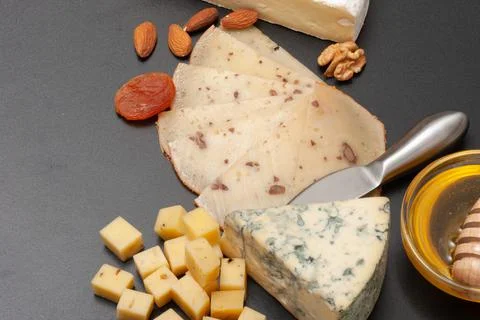 Different types of cheese on a graphite board top view Stock Photos