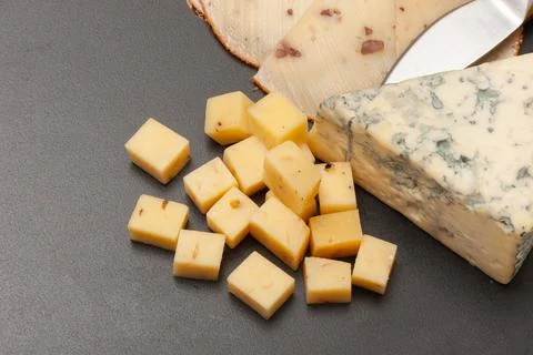 Different types of cheese on a graphite board top view Stock Photos
