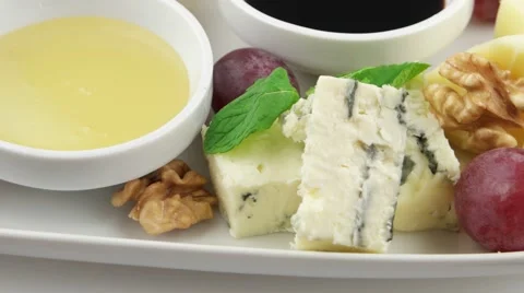 Different types of cheese on a white long plate (loop) Stock Footage 58001343