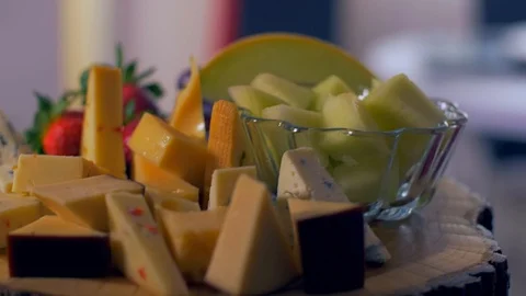 Different types of cheeses on a wooden board look very appetizing Stock Footage 109129143