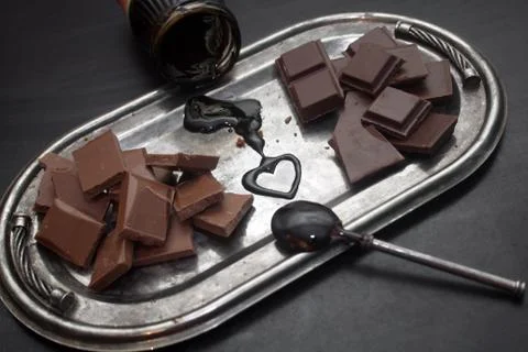 Different types of chocolate on a silver tray on a black background Stock Photos