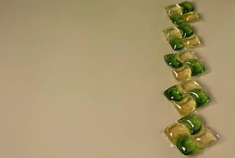 Different types of cleaning pods arranged in a line on a plain surface during Foto stock