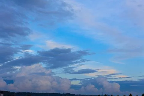 Different types of clouds in the blue sky at sunset Stock Photos