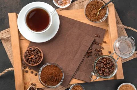 Different types of coffee and a cup of coffee on a brown background. Top view Stock Photos