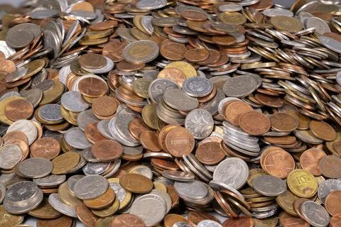Different types of coins scattered all over a flat surface Stock Photos