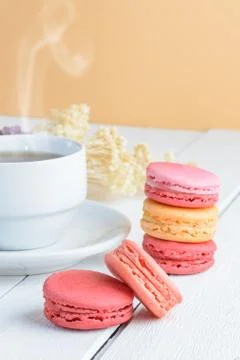 Different types color of macaroons with Cup of hot tea on white wooden backgr Stock Photos