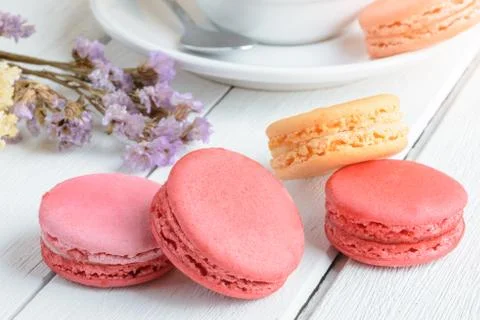 Different types color of macaroons with Cup of hot tea on white wooden backgr Stock Photos
