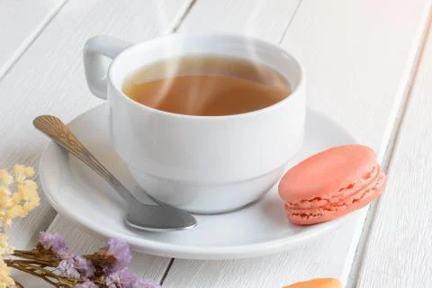 Different types color of macaroons with Cup of hot tea on white wooden backgr Stock Photos