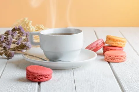 Different types color of macaroons with Cup of hot tea on white wooden backgr Stock Photos