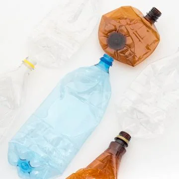 Different types of crushed plastic bottles on white background. Recyclable wa Stock Photos