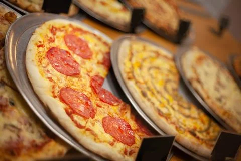 Different types of delicious pizza on the table with tomatoes and cheese Stock Photos