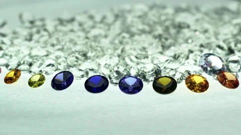 ..different types of diamonds are arranged in a row in front of a pile of whi Stock Footage 252433024