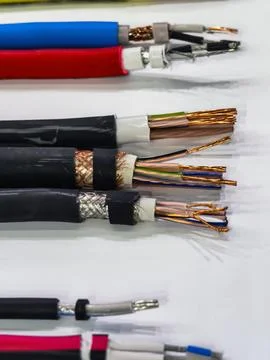 Different types of electrical wires and cables arranged on a white surface .. Foto stock