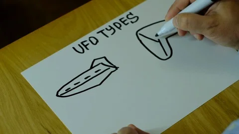 Different types of extraterrestrial flying vehicles drawn on paper Stock Footage 129836168