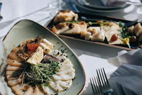 Different types of fish on a plate. Wedding table setting with food in restau Stock Photos