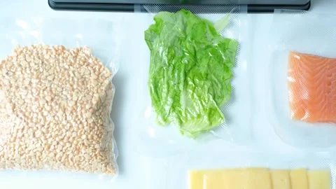 Different types of food packed in vacuum bags on white background top view. Stock Footage 280373328